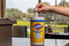 Person getting a disinfectant wipe from a clorox container