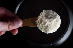 creatine powder being scooped into a cup