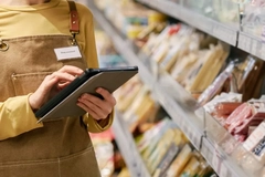 A person holding a tablet in a grocery store