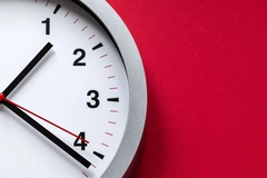 white and black clock on red wall