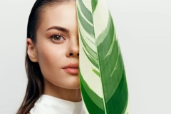 IFF biotech beauty science A woman with a leaf in front of her face.