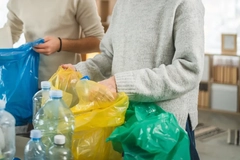 Two people holding bags of garbage