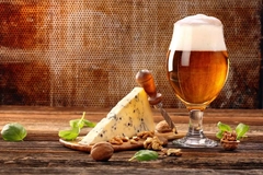 Cheese and beer on a wooden table.