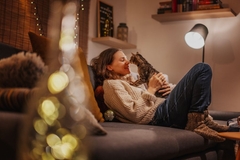 Image woman sits on couch with cat