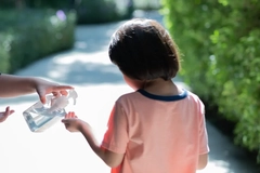 A child getting soap from a hand