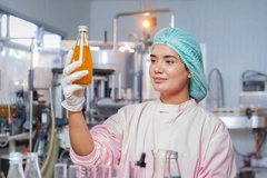 Image Scientist in food lab holding up a beverage