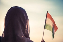 Woman wearing a hijab and holding an Iranian flag