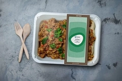Image A container of food with a lid and a couple wooden spoons