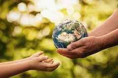 Senior hands giving a small planet earth to a child's hands