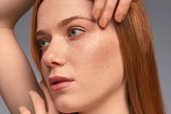 Image Woman with freckles touching her face