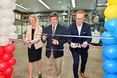 two men and a woman cutting ribbon at innauguration