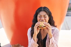 Young consumer eating plant-based burger.
