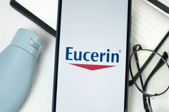 Image Eucerin written on a phone next to a pair of glasses.