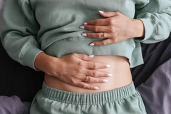 Image woman holding hand on stomach for gut health