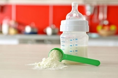 Image Feeding bottle and baby milk formula on kitchen background