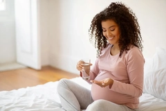 Image pregnant woman taking prenatal supplement