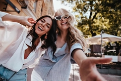 Image Two women together smiling in the sun.