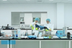 Image Two people in white coats and blue hair caps