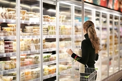Image woman in frozen food aisle in supermarket