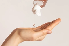 Lube being put into the palm of someone's hand.