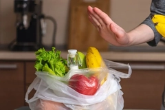 Image A hand with a bag full of groceries