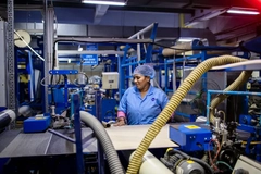 Image woman operating machinery in packaging factory