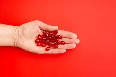 Image hand holding krill oil supplements