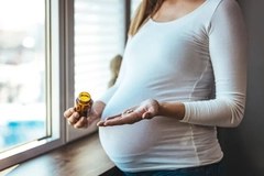 Image pregnant woman taking supplement