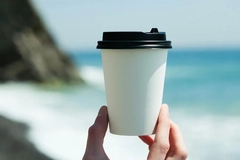 paper cup against ocean
