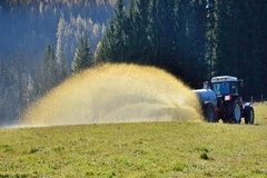 Image Tractor spraying fertilizer over a field.