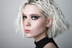 Image Woman with futuristic hair and makeup against white backdrop
