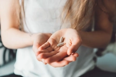 Woman holding capsules in hand