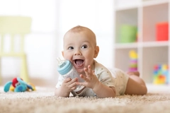 Image Infant holding milk bottle