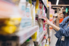 Image A person scanning a product on a shelf with a smartphone