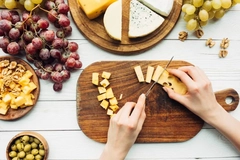 Image person cutting cheeses for platter