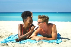 Image Two people lying on the beach.