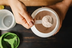 woman scooping protein powder