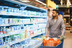 Image Man shopping for groceries in supermarket dairy aisle