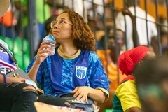 woman drinking water at football game