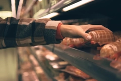 Image hand picking up packed meat in supermarket