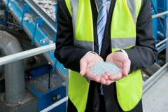 Image A person holding a handful of granules