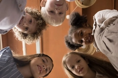 Image Kids looking down in a circle.