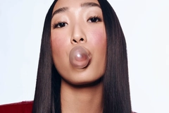 Image Woman blowing a bubble with gum