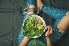 Image Woman eating dark leafy greens salad