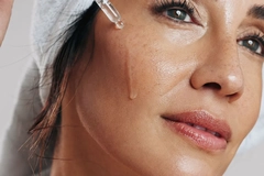 Image Middle aged woman doing her skin care in a mirror
