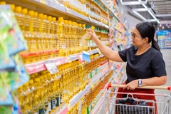 Woman shopping for vegetable oil in the supermarket.