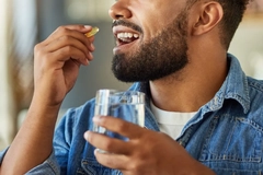 Image man taking omega 3 supplement capsule