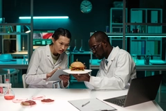 two scientists analyzing burger with cultivated meat in lab