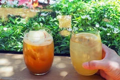 Image hand holding a glass of sparkling yuzu drink