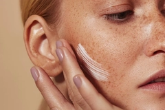 Image Woman applying skin cream to her cheek